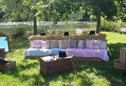 Canapé rustique en bottes de foin avec coussins roses/gris, près d'un lac, sous les arbres à Autrèche près de Tours et d'Amboise en Indre-et-Loire 37