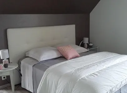 Chambre moderne avec lit blanc, tête de lit capitonnée, coussin rose et lampes de chevet à Autrèche près de Tours et d'Ambois en Indre-et-Loire 37