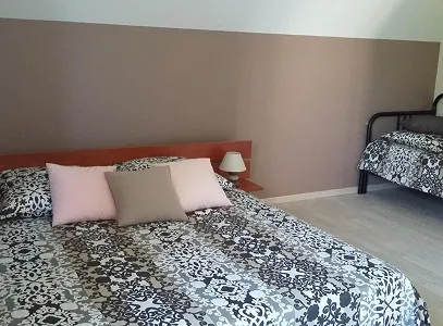 Chambre à coucher avec grand lit à motifs gris et noir, petit lit simple et murs bruns à Autrèche près de Tours et d'Ambois en Indre-et-Loire 37