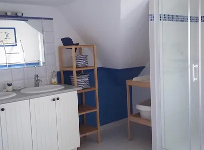Salle de bain lumineuse avec double vasque, douche, et étagères en bois bleu et blanc à Autrèche près de Tours et d'Ambois en Indre-et-Loire 37