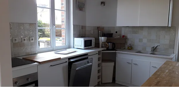 Cuisine blanche moderne avec fenêtre, appareils électroménagers, carrelage et comptoirs à Autrèche près de Tours et d'Amboise en Indre-et-Loire 37